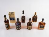 several bottles of liquor are lined up on a white surface