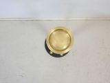 a gold plate sitting on the floor next to a white wall