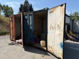 un grand conteneur ouvert posé au milieu d'un parking