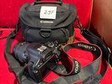 un gros plan d'un appareil photo et d'un sac pour appareil photo posés sur une chaise rouge