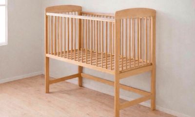 un lit de bébé dans un coin de la pièce, près d'une fenêtre