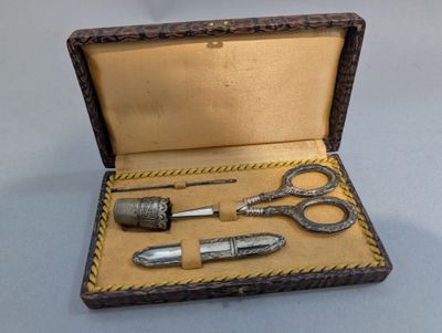 une boîte avec une paire de ciseaux et une paire de ciseaux à l'intérieur