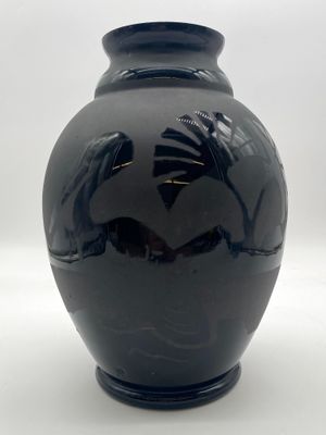 a black vase with a bird design on it