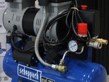 a blue air compressor sitting on top of a table next to a box
