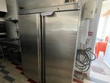 un réfrigérateur en acier inoxydable dans une cuisine au sol en damier