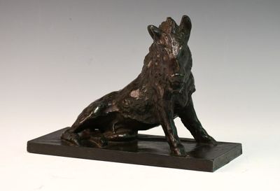 sculpture en bronze représentant un chien assis sur un socle, sur fond blanc