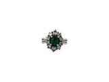 gros plan d'une bague en diamant et émeraude sur fond blanc