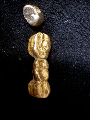 une pépite d'or et une pièce de monnaie sur un fond noir