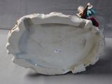 a figurine of a man and a woman sitting on a shell