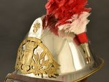 a silver helmet with a red flower on top of it