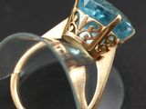 an image of a gold ring with a blue topaz stone