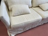 a white couch with two pillows on it in a room