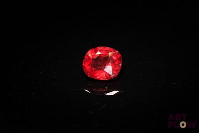 un diamant rouge sur une surface noire