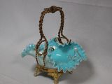 a blue glass teapot with a gold handle on a white background