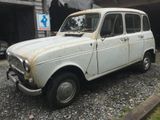 une vieille voiture blanche garée devant un garage