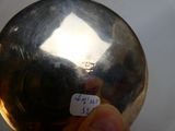 a person holding a silver ball with a sticker on it