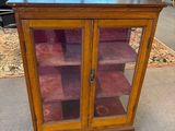 une vitrine en bois avec des portes vitrées et des étagères dans un magasin