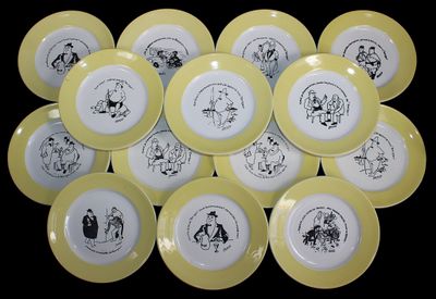 yellow and white plates with black drawings on them on a black background