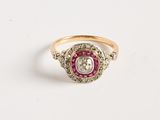 un gros plan d'une bague en or ornée d'un diamant rose et blanc en son centre