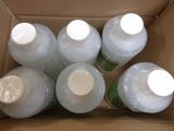 six bottles of water are in a cardboard box on a table