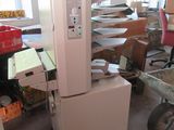 une photo d'un réfrigérateur dans une pièce où se trouvent de nombreux cartons par terre