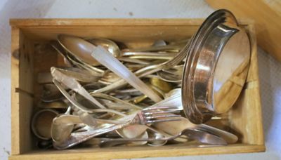 une boîte en bois remplie de cuillères en argent et de cuillères