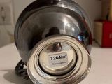 a silver bowl sitting on a counter with a tag on it