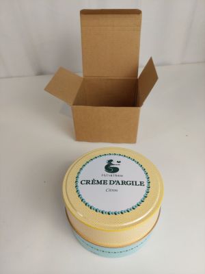 le récipient se trouve à côté d'une boîte de crème d'orcile