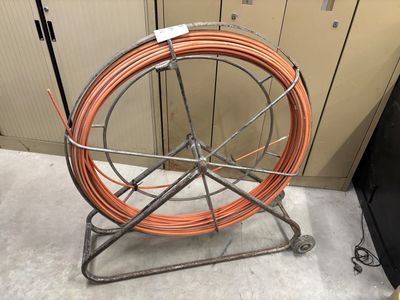 a large orange hose on a metal stand in a room