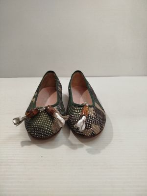 pair of women ' s shoes with bows on them sitting on a table
