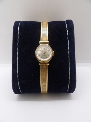a close up of a watch on a velvet case on a white surface