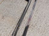 two golf clubs laying on the ground next to each other