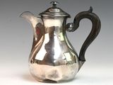 a silver coffee pot sitting on a white surface