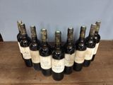 six bottles of wine are lined up on a wooden table