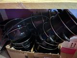 many pots and pans in a box on the floor