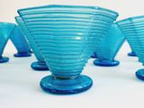 several blue glass vases sitting on top of a white table