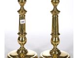 a pair of brass candlesticks on a white background