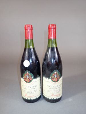 two bottles of wine sitting on top of a table next to each other