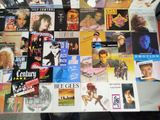 a table covered with many different types of vinyl records