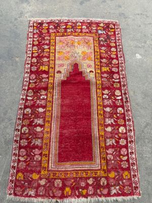 a red and yellow rug with a red design on it