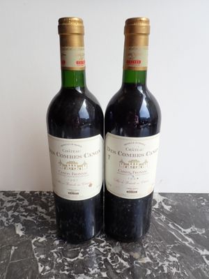 two bottles of wine sitting on top of a table next to each other
