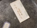 a piece of paper with writing on it sitting on a metal plate