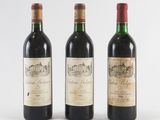 three bottles of wine are lined up on a white surface