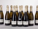 six bottles of champagne lined up in a row on a table