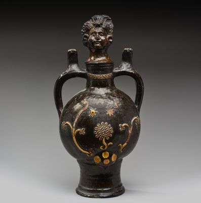 un vase noir et doré orné d'une tête de lion