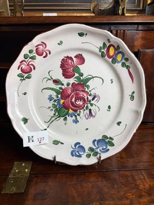 a plate with flowers on it sitting on a wooden table