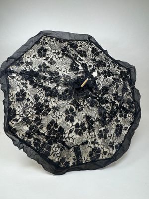 un parapluie en dentelle noir et blanc avec un manche en bois