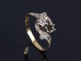 a gold and diamond ring on a black surface