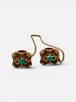 pair of gold earrings with green stones on a white background