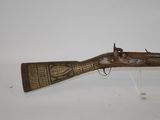 an old gun with a wooden handle on display on a white surface